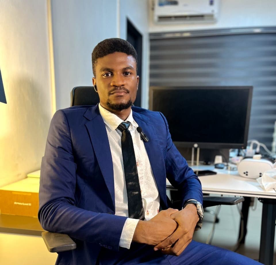 Makinde David Craig at a desk, with a Meta Quest headset beside the monitor